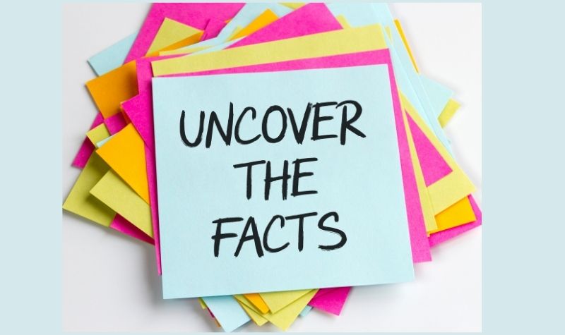 A post it note with uncover the facts